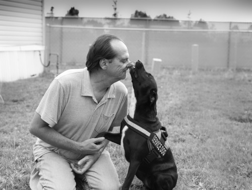 Sexual assault survivor Joe poses with his dog, who is an important part of his recovery process.